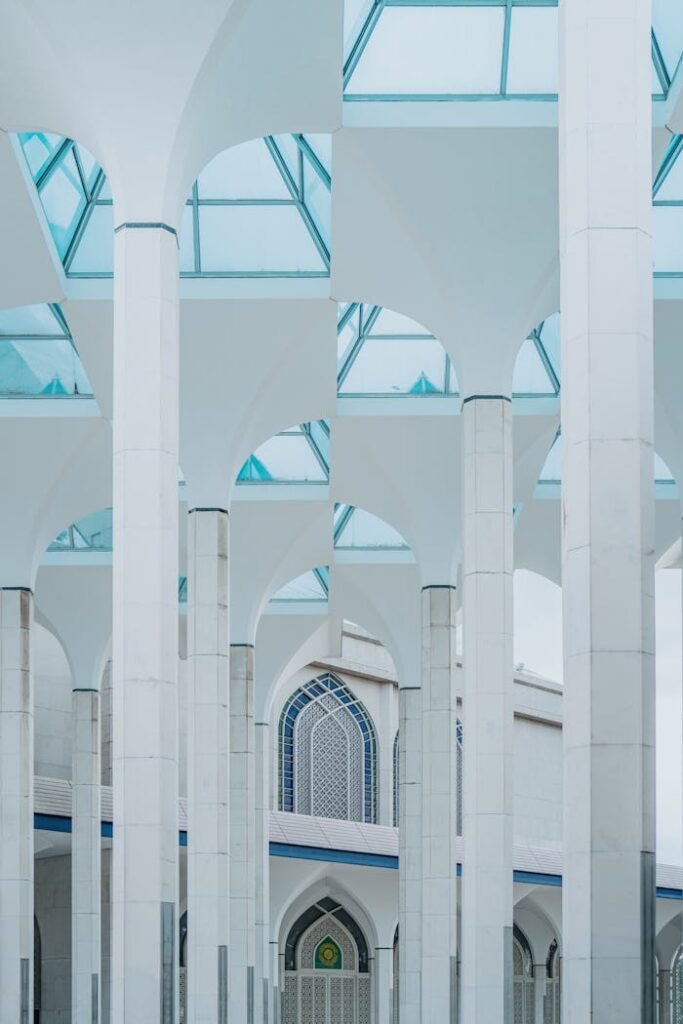 Intricate arches and pillars of Shah Alam Mosque showcasing Islamic architecture.
